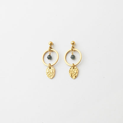 A pair of gold dangle earrings with circular hoops, small dark gray bead accents, and textured leaf-shaped charms, displayed on a clean white background.