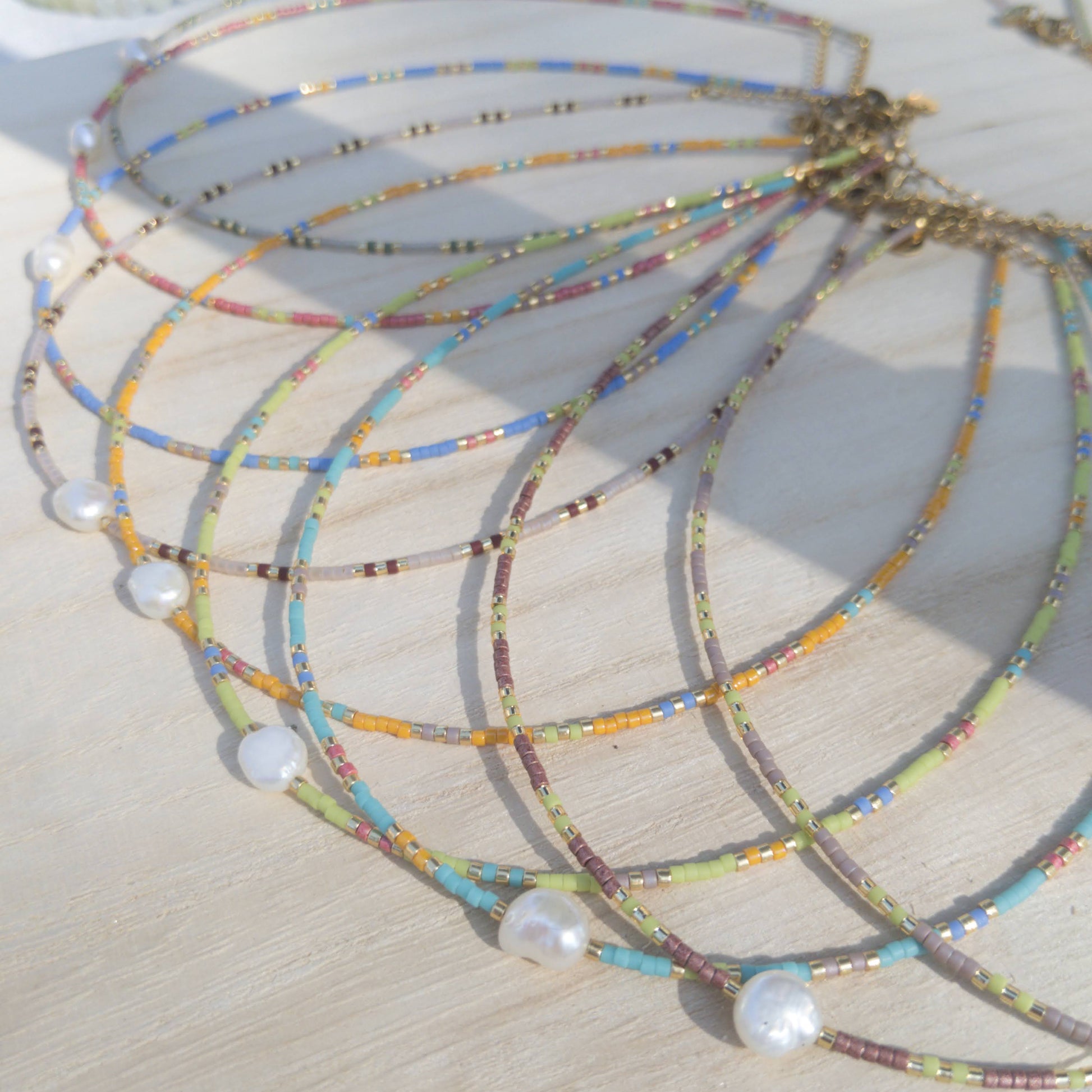 Colourful beaded necklaces with pearls on a wooden stand