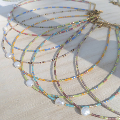 Colourful beaded necklaces with pearls on a wooden stand