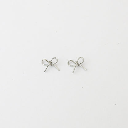 A pair of small silver bow-shaped stud earrings on a plain white background.