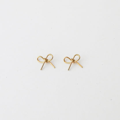 A pair of small gold bow-shaped stud earrings on a plain white background.