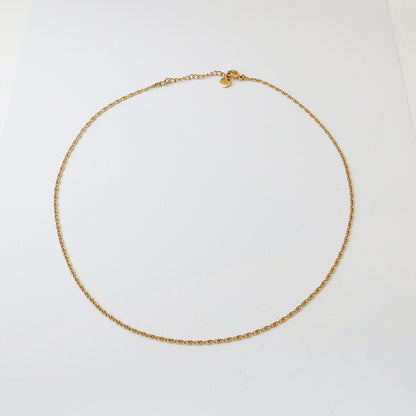 A delicate gold chain necklace with a small heart charm, displayed on a clean white background.