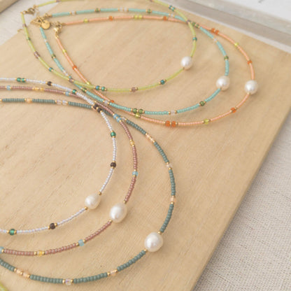 Set of colourful beaded necklaces on a wooden surface