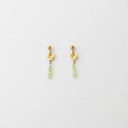 A pair of gold dangle earrings with ornate circular charms and small light green bead drops, displayed on a clean white background.