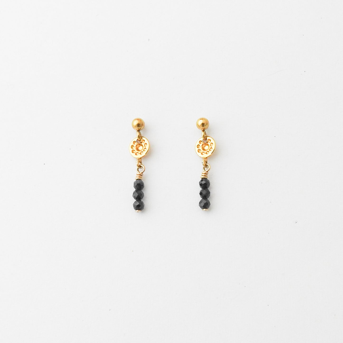 A pair of gold and black beaded dangle earrings on a clean white background.
