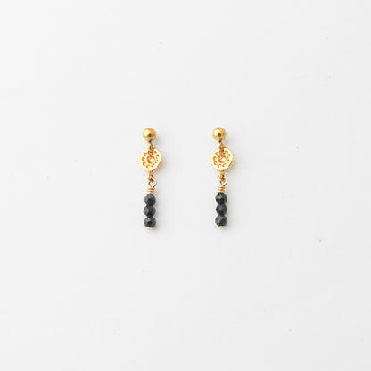 A pair of gold and black beaded dangle earrings on a clean white background.