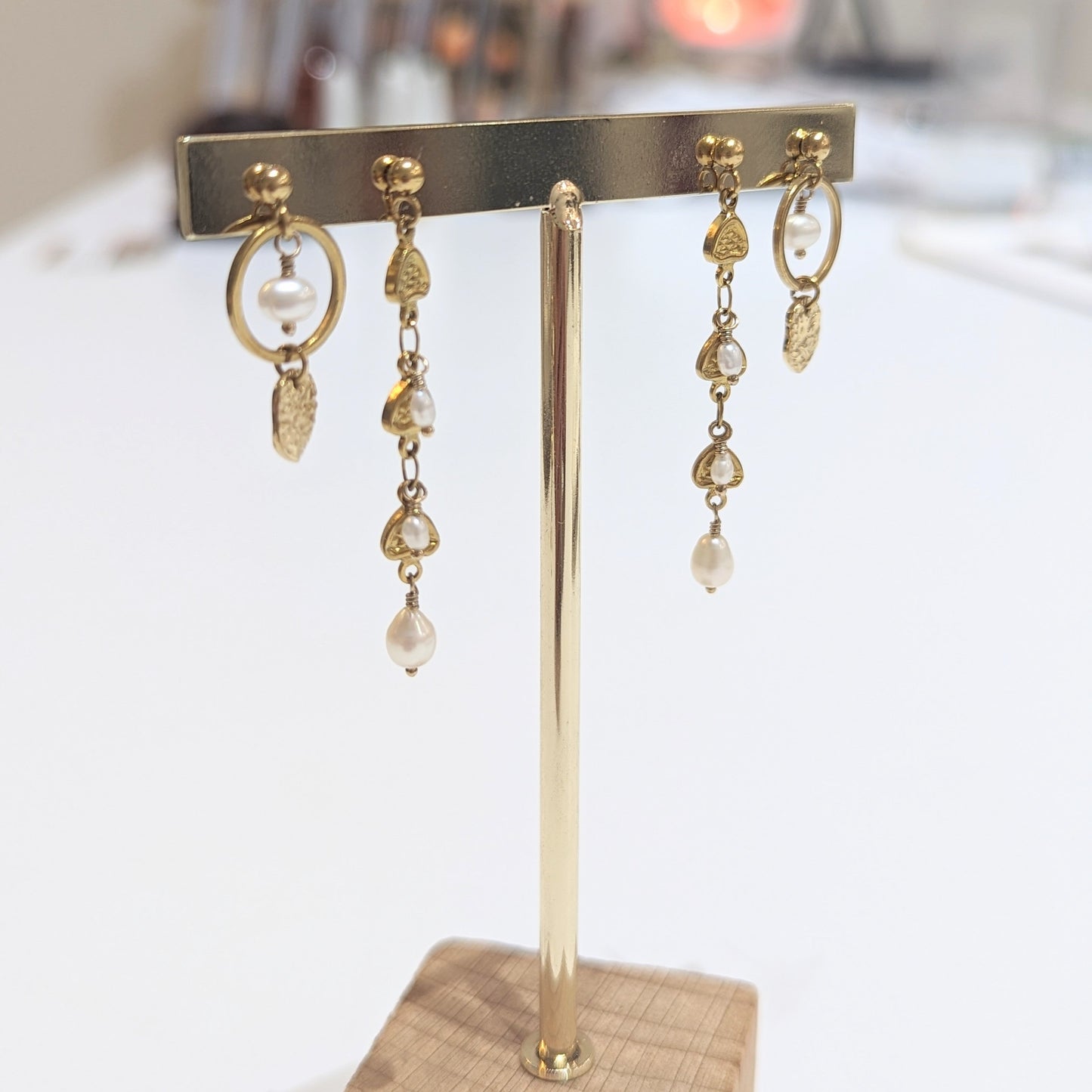 Gold earring stand with hanging earrings on a blurred background