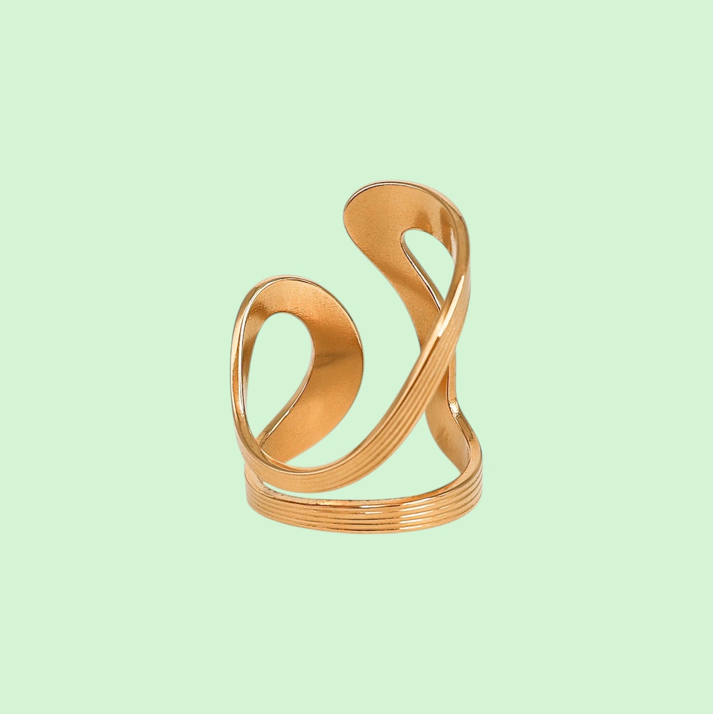 Gold spiral ring on a light green background