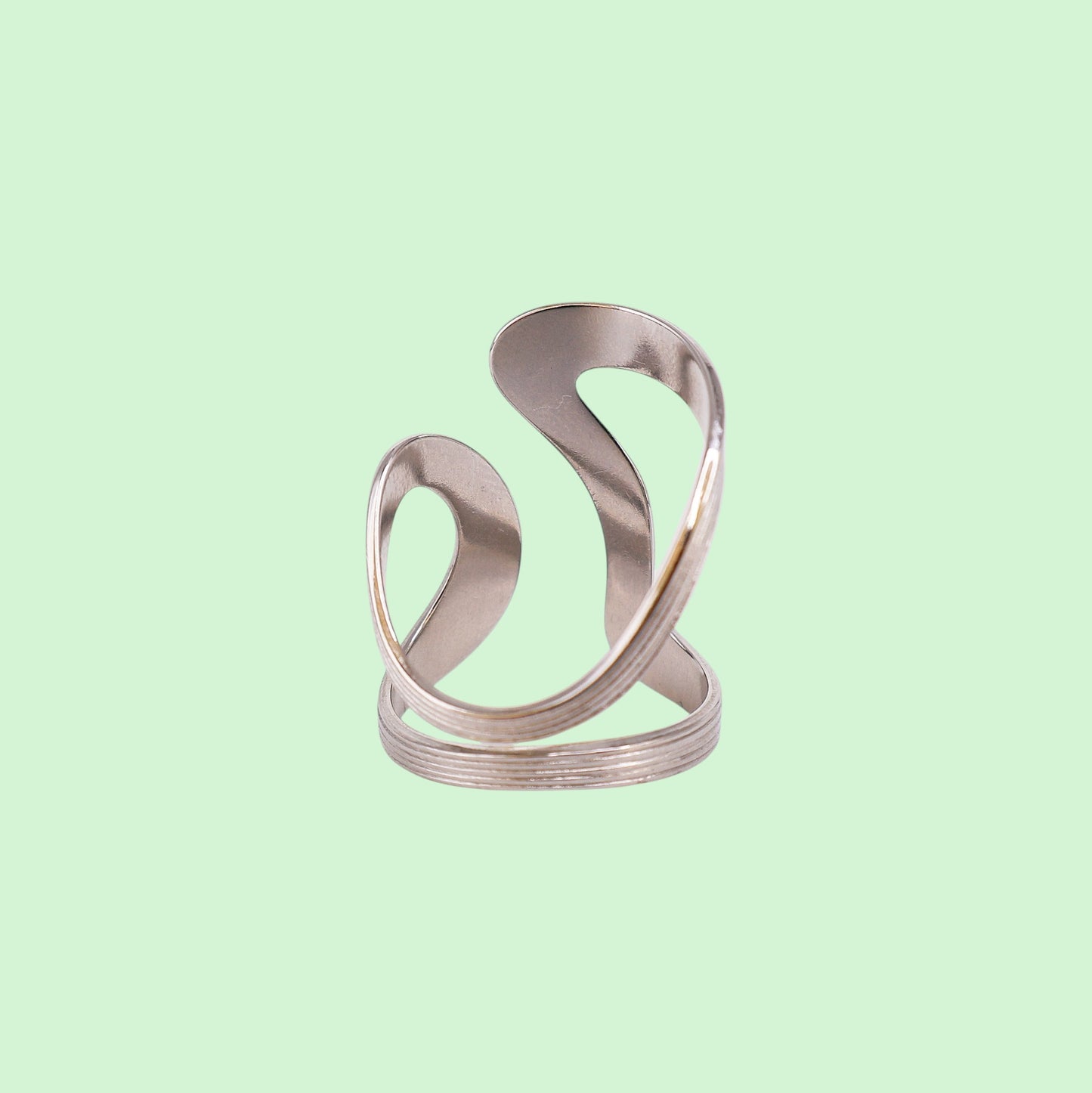 Metallic silver ring on a light green background