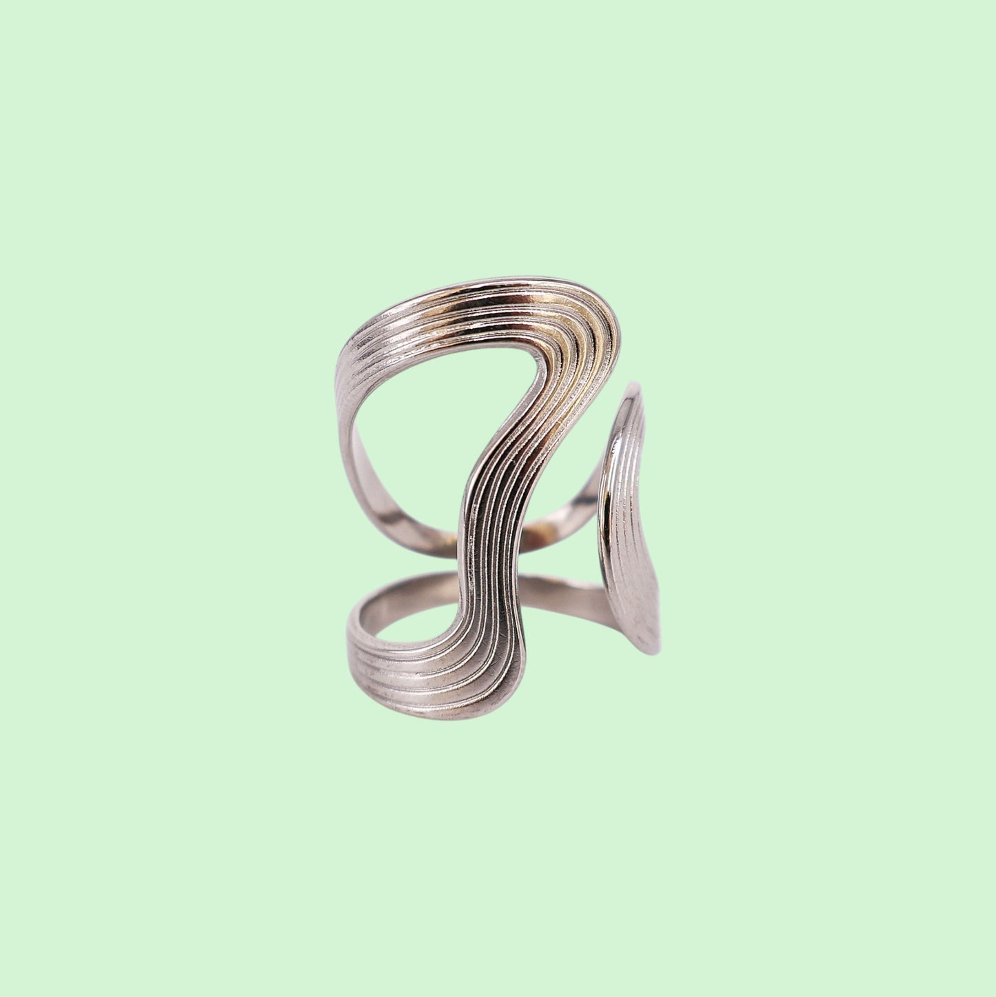 Silver spiral ring on a light green background